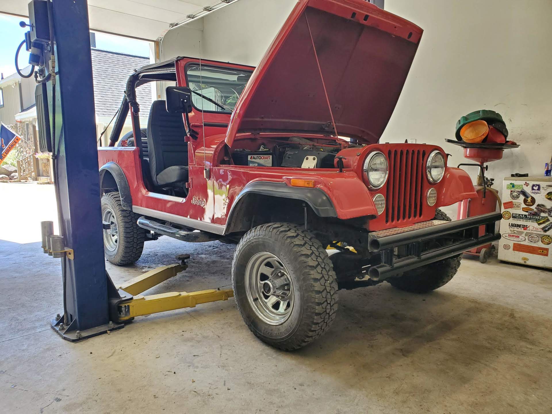 1987 Jeep CJ in the shop with the hood popped