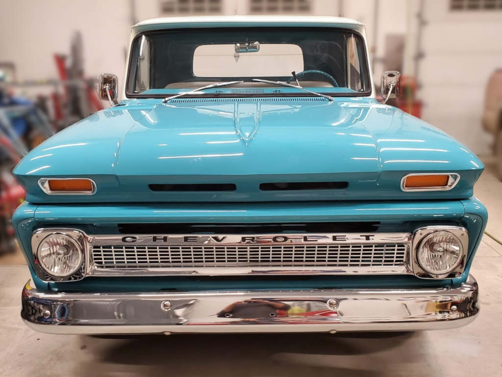 Shiny front grill of a light blue Chevrolet C10 restomod